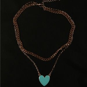 Women’s gold necklace with a blue heart